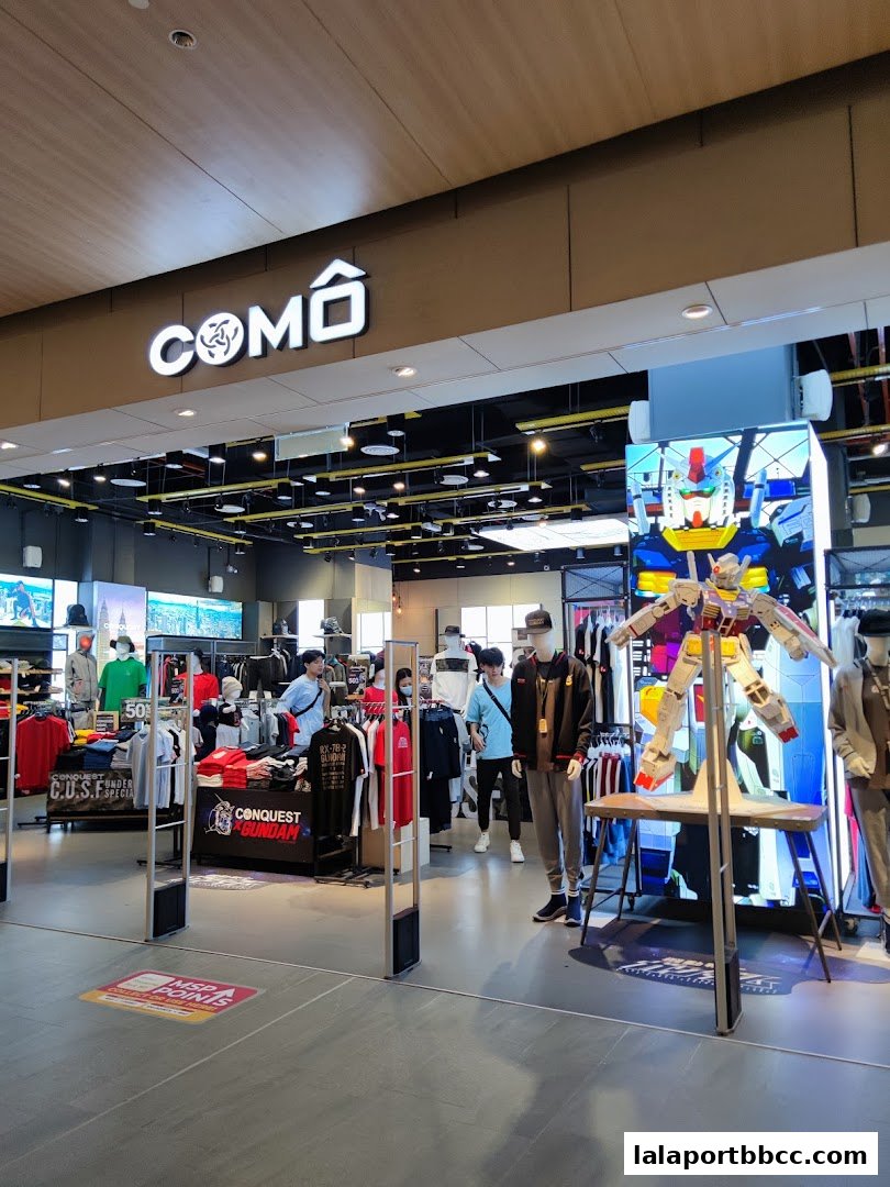 The entrance of a clothing store with mannequins and apparel displayed.
