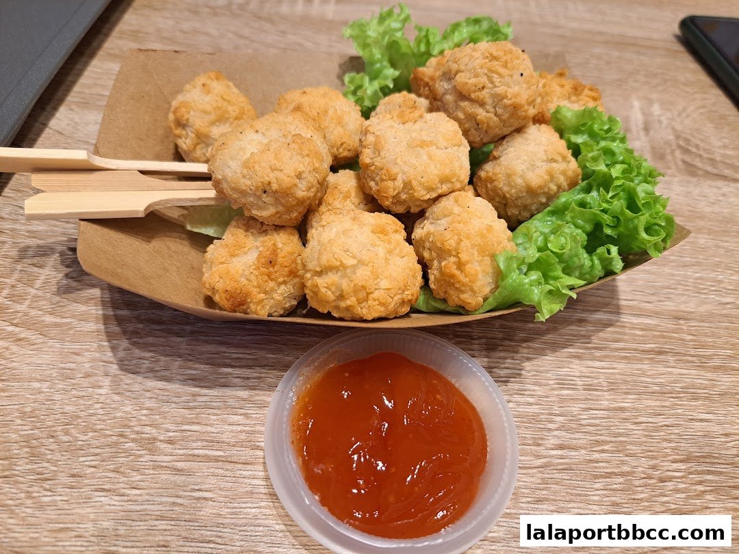Crispy fried chicken bites served with lettuce and a side of sweet chili sauce.