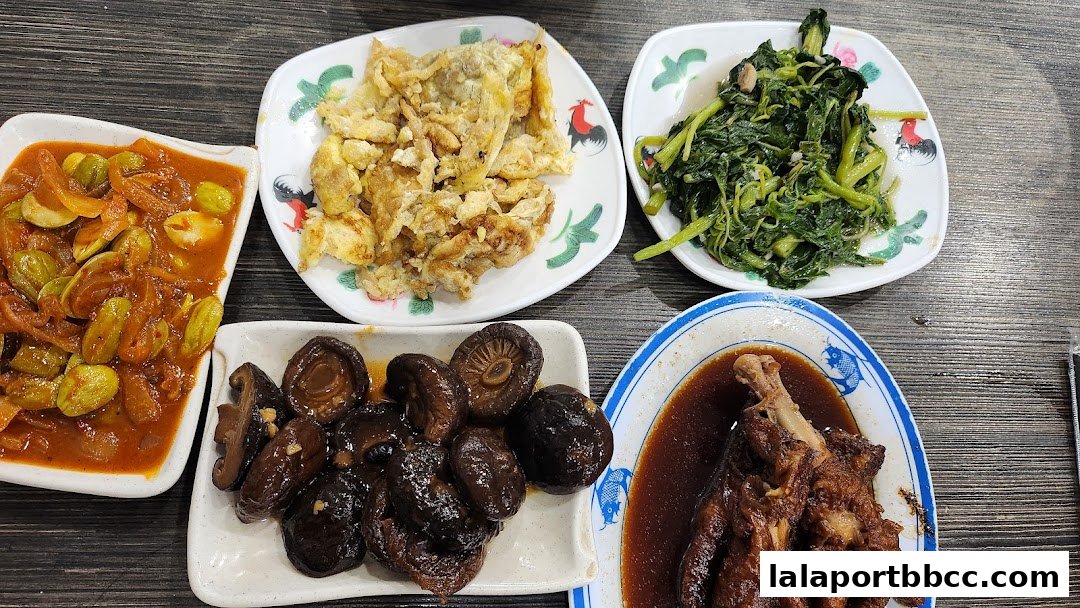 A spread of delicious Teo Chew dishes including stir-fried vegetables, petai, mushrooms, and braised chicken feet.