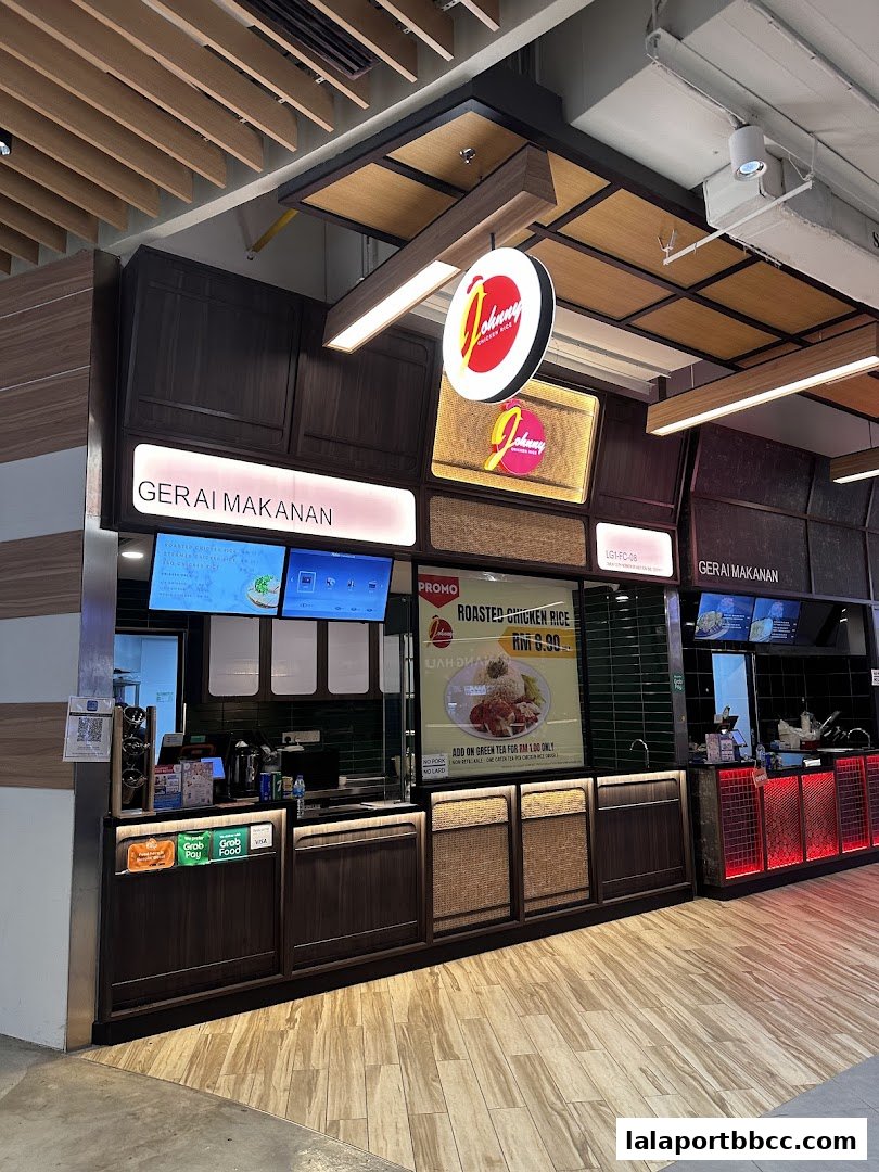 The Johnny Chicken Rice LaLaport shop front with a promotional poster for roasted chicken rice.