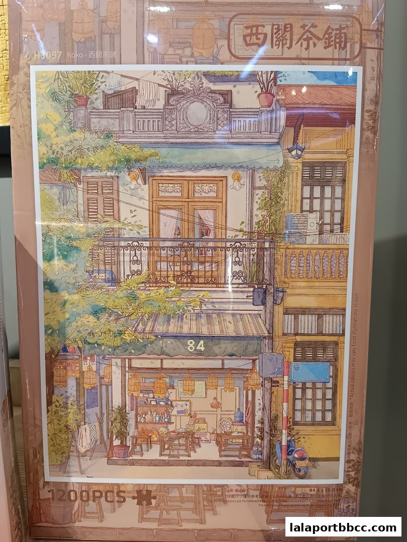 A puzzle box featuring an illustration of a charming street scene with a tea shop.