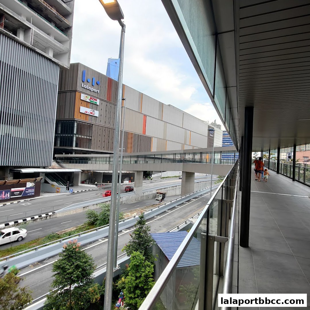 A view from a skybridge showing a modern building complex and a busy street below.