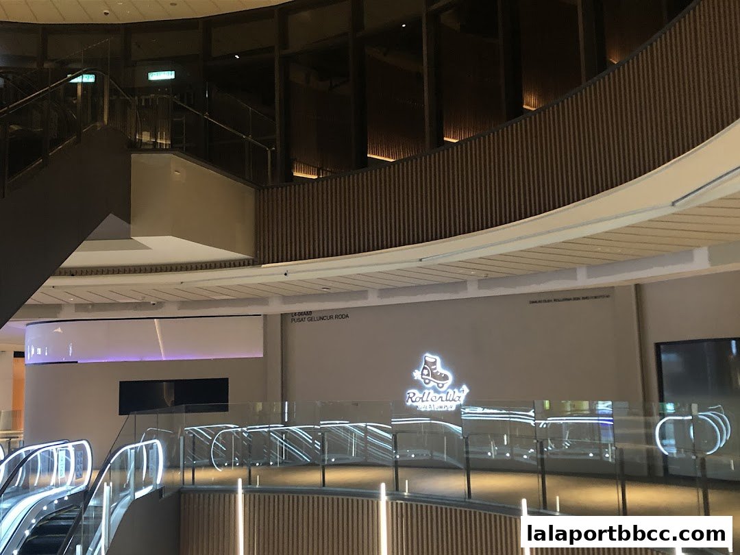 Interior view of a modern shopping mall with escalators and the Rollerwa logo visible.