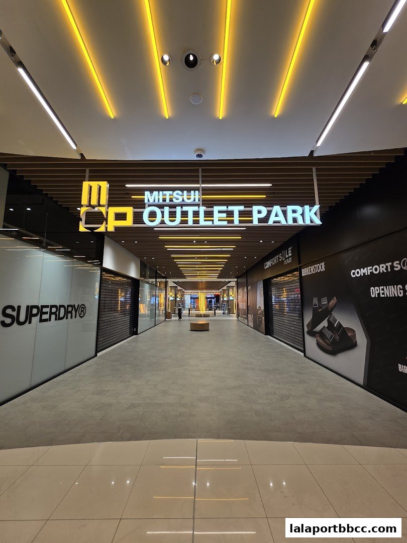 A wide view of a modern shopping mall interior with the Mitsui Outlet Park sign prominently displayed.