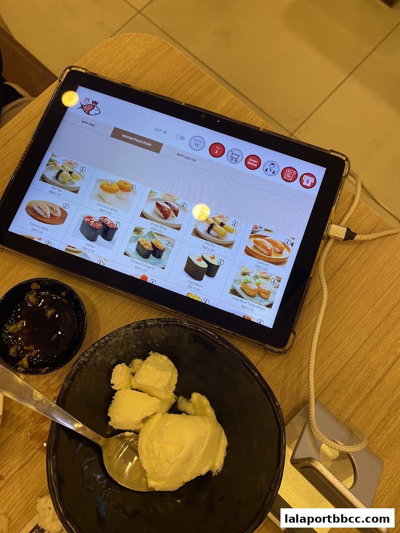 A tablet displaying a sushi menu with various sushi items and prices.