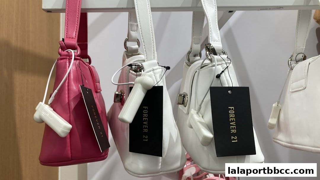 A close-up shot of several stylish handbags in pink and white, with 'Forever 21' tags attached.