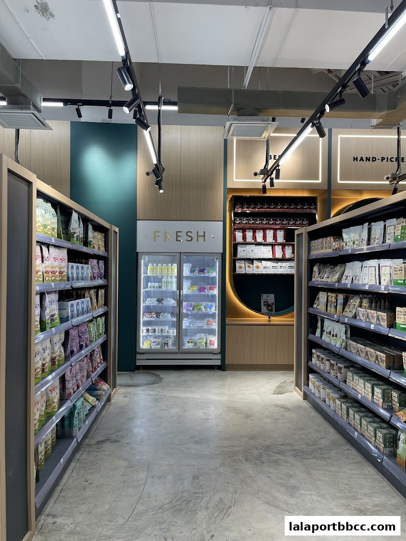 Interior view of a grocery store with shelves stocked with products and a refrigerated display.