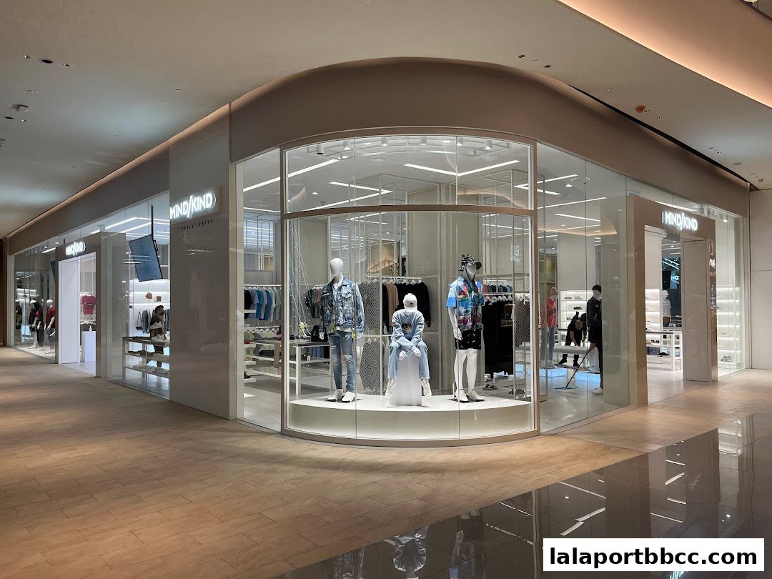 The exterior of a modern clothing store with mannequins displaying stylish outfits in the window.