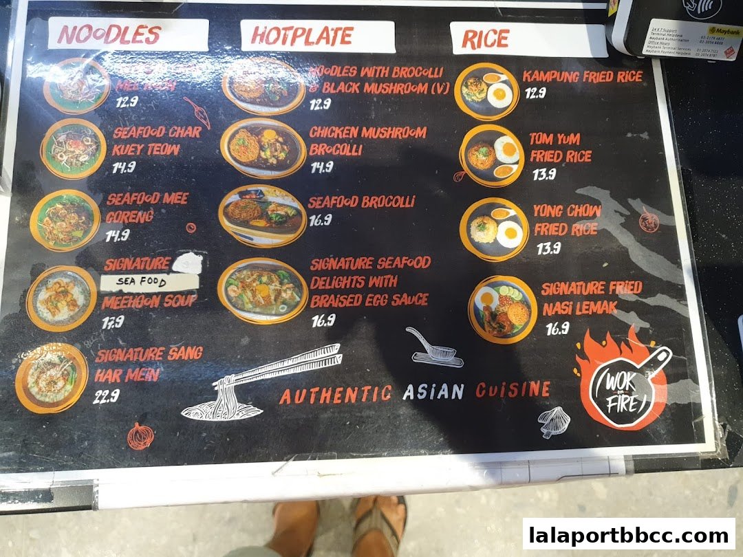 A menu board for Wok On Fire LaLaport, showcasing Asian cuisine with categories for noodles, hotplate, and rice dishes.