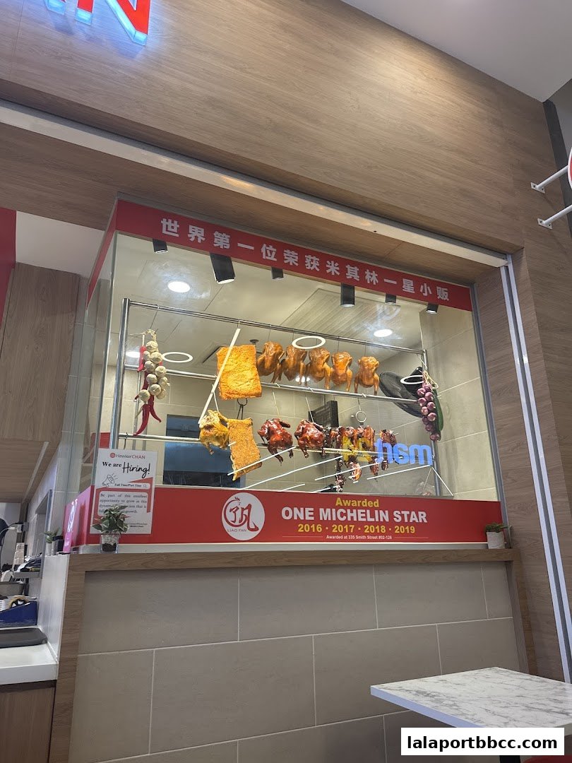 Hawker Chan shop front displaying roasted meats and Michelin star awards.