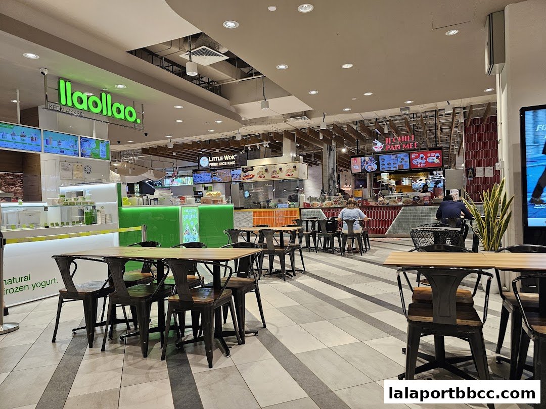 A food court with various eateries, including llaollao, Little Wok, and Ipoh Mali Pan Mee.