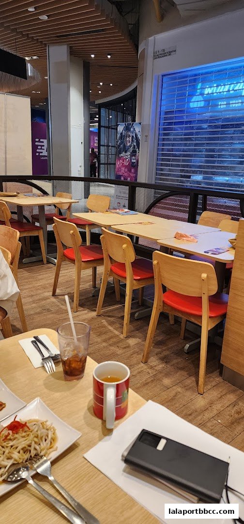 Interior view of a restaurant with tables, chairs, and food on a table.