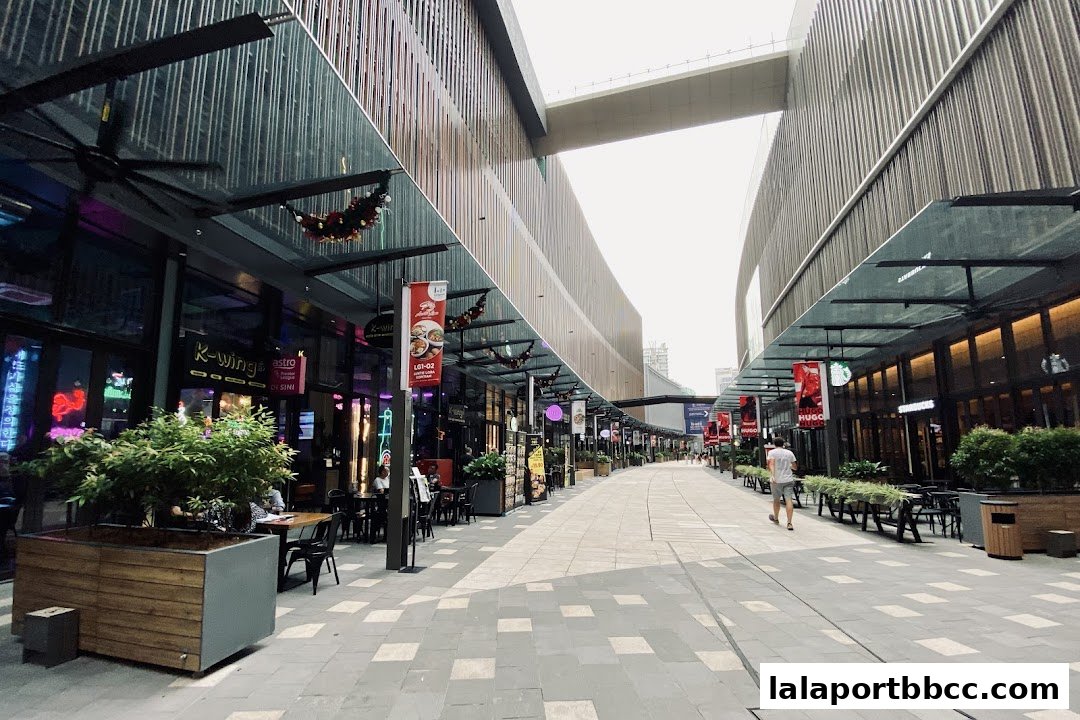 A pedestrian walkway lined with shops and outdoor seating areas.
