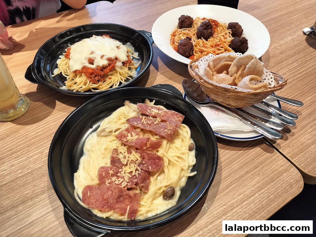 Three delicious pasta dishes and a basket of crackers are arranged on a wooden table.