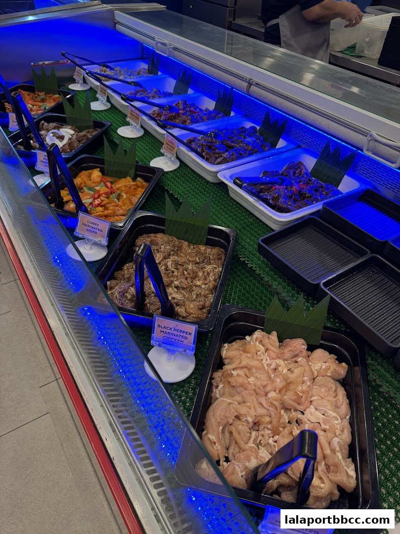 A display of marinated meats and seafood in a refrigerated case with blue lighting.