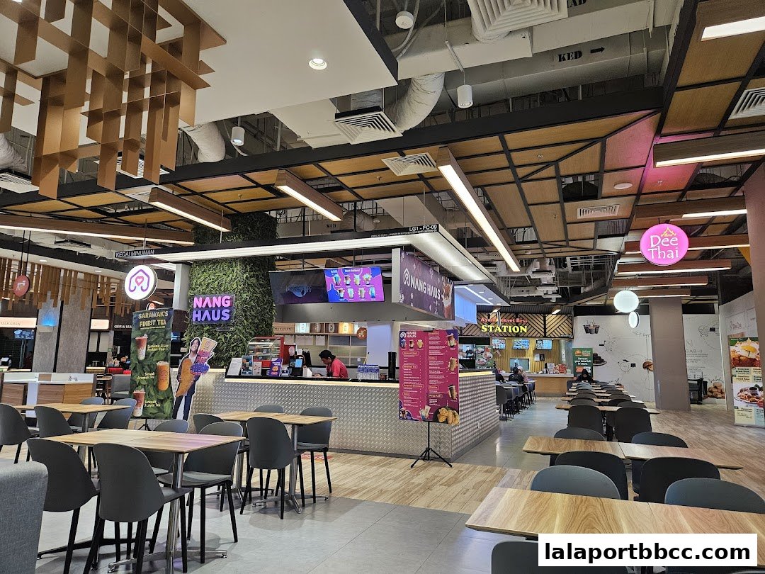 A food court with various eateries, including Nang Haus and Dee Thai, and seating areas.