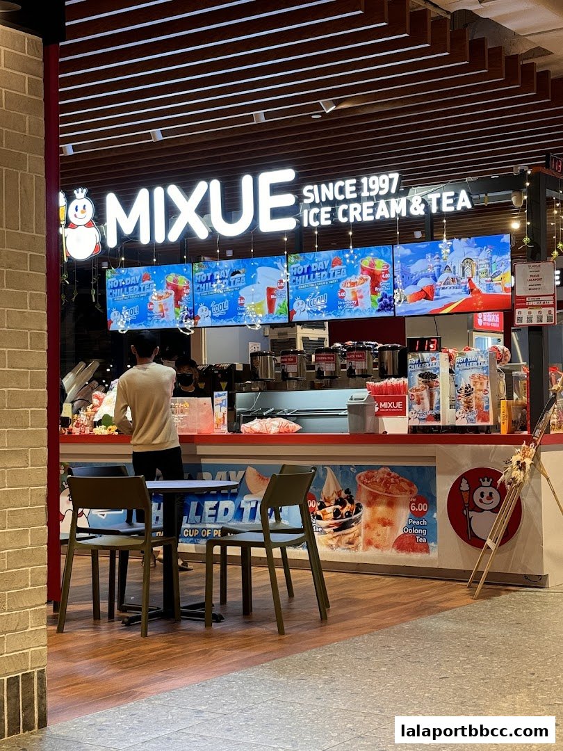 A Mixue Ice Cream & Tea shop with a customer at the counter and seating area.