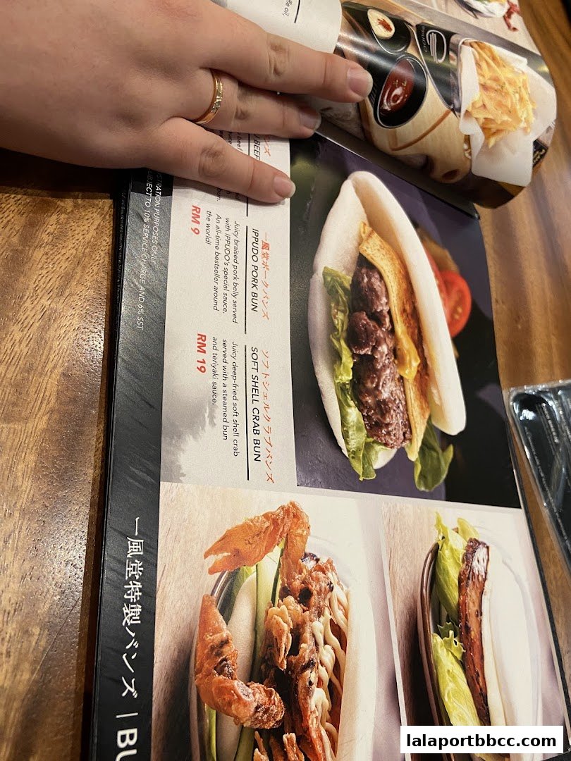 A close-up of a menu featuring delicious pork buns and soft shell crab buns.