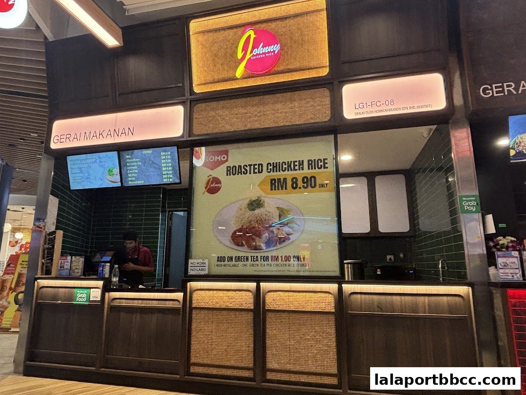 Johnny Chicken Rice LaLaport shop front with a prominent display of roasted chicken rice.