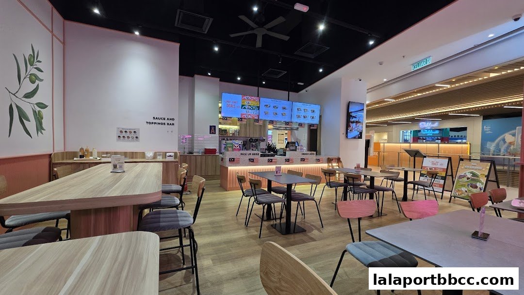 Interior view of a modern eatery with tables, chairs, and digital menu boards.