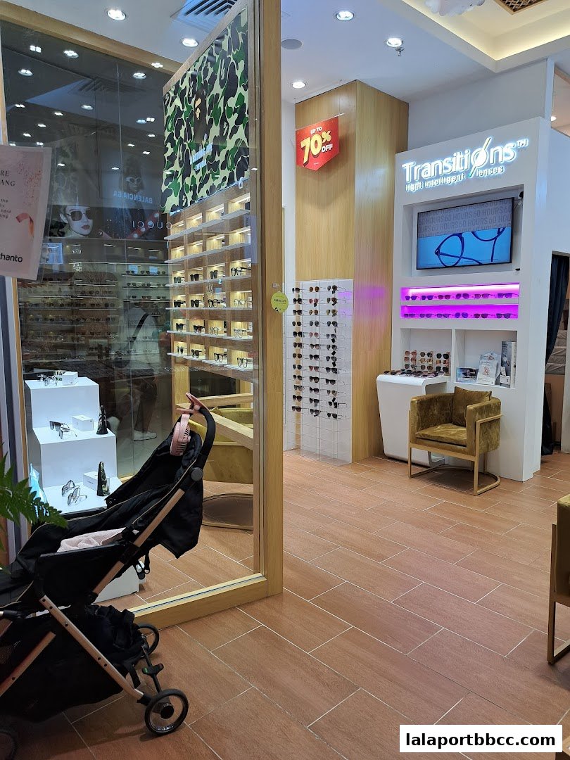 Interior of an optical shop showcasing eyewear displays and a promotional sign.