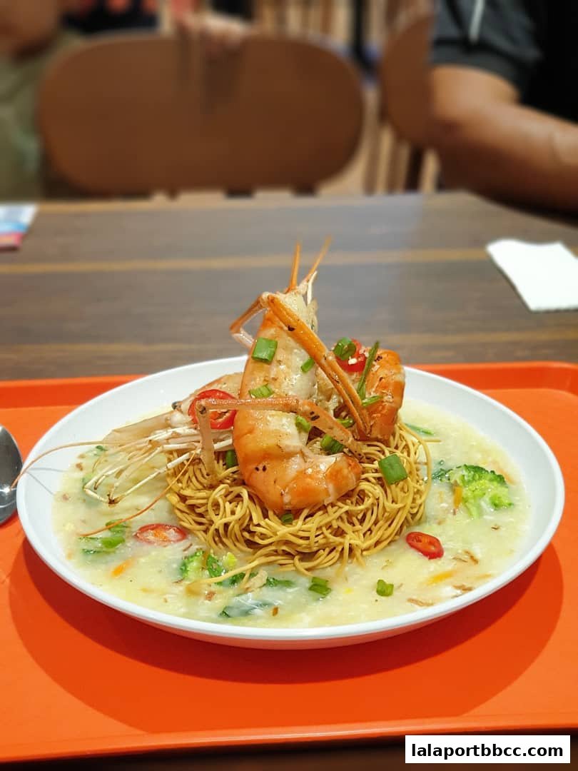 A delicious bowl of crispy noodles topped with large prawns and vegetables in a creamy sauce.