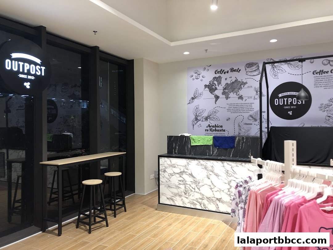 Interior of a modern coffee shop with a counter, seating, and merchandise display.