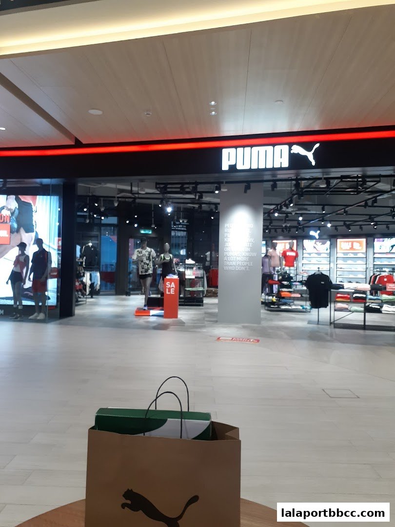 The PUMA store entrance with merchandise displays and a 'SALE' sign.