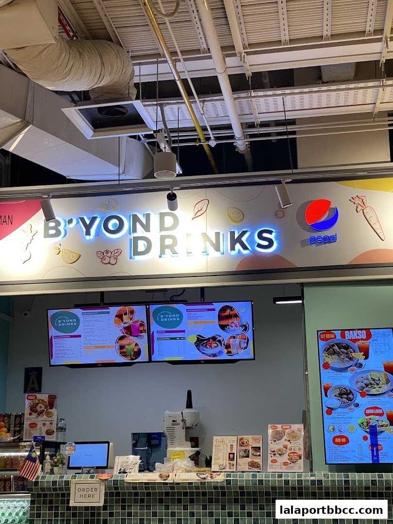A food stall counter with digital menus displaying drinks and food, and a Pepsi logo.