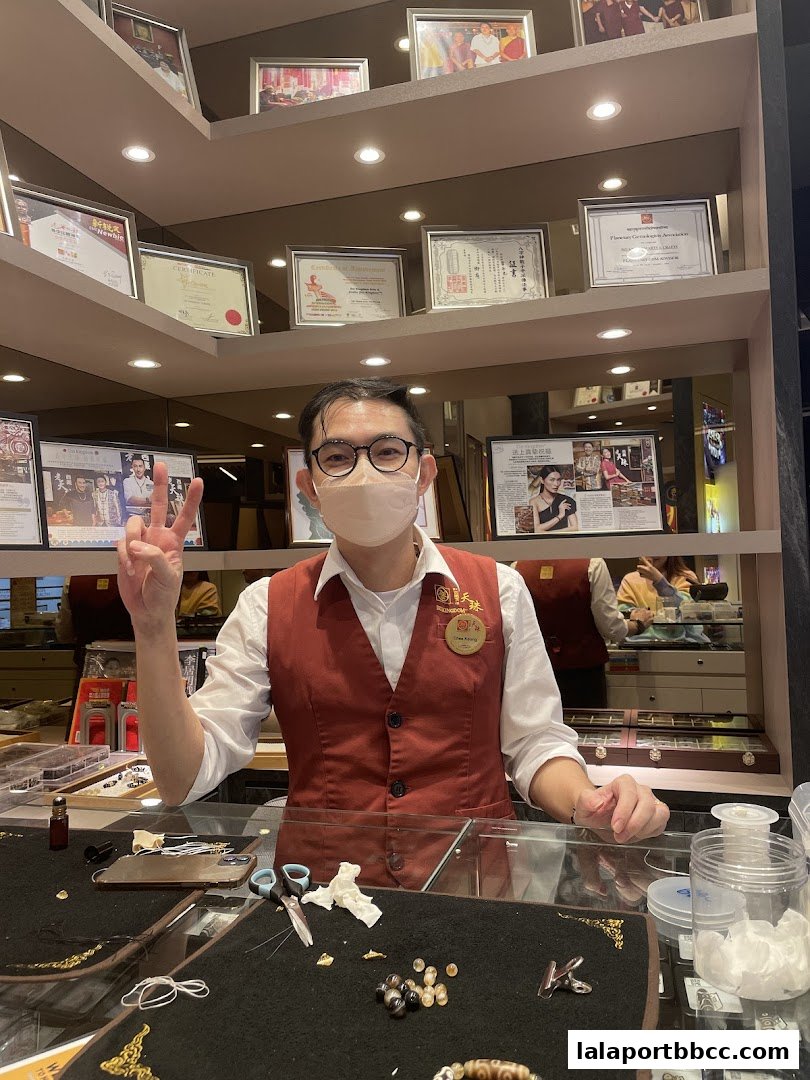 A shop assistant at Dzi Kingdom, Lalaport Bukit Bintang City Centre, shows a peace sign.
