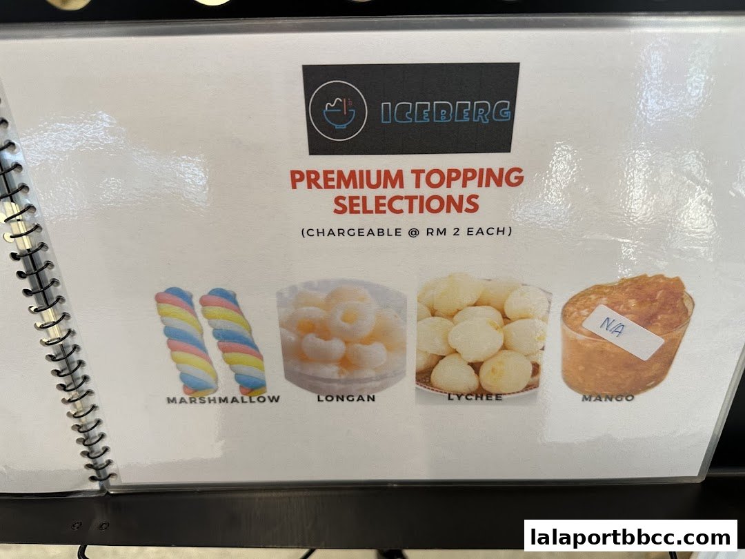 A menu showcasing premium topping selections with images of marshmallows, longan, lychee, and mango.