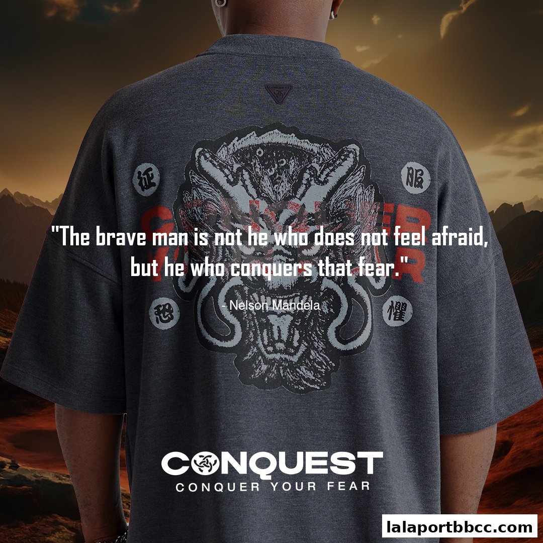 A person wearing a dark grey t-shirt with a dragon graphic and a quote.