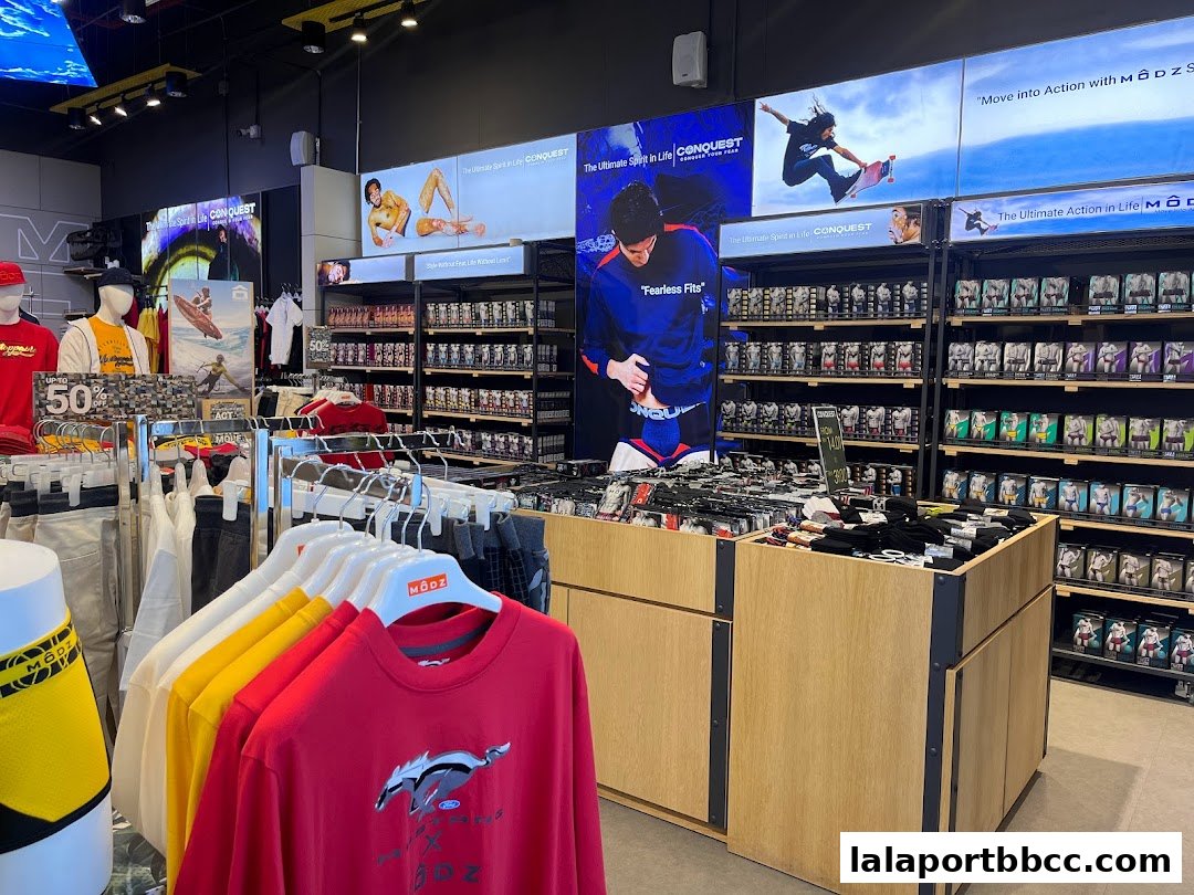 Interior view of a clothing store showcasing activewear and apparel on display racks and shelves.