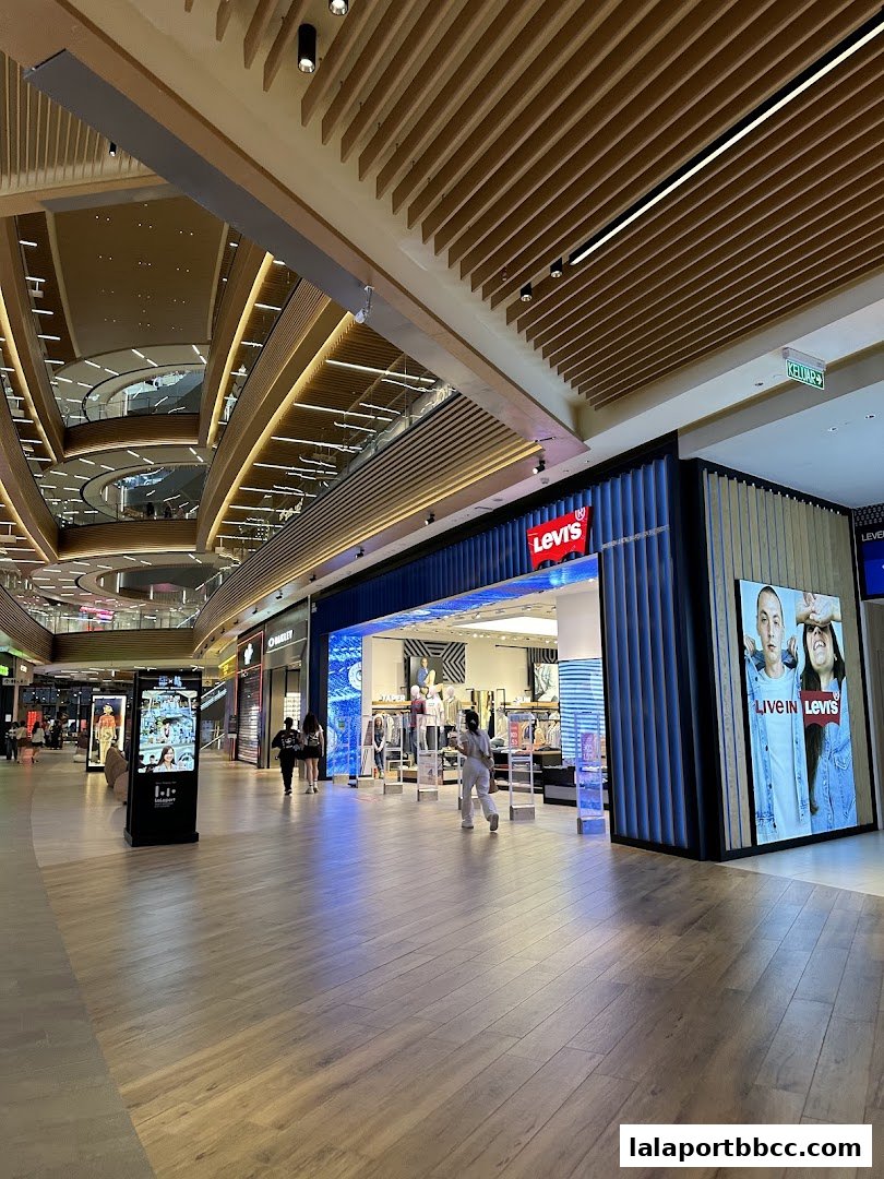 The exterior of a Levi's store in a modern shopping mall with people walking by.