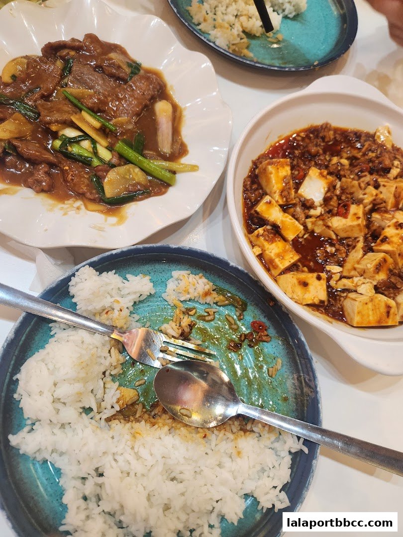 A close-up of delicious Asian dishes, including beef with vegetables and mapo tofu, served with rice.