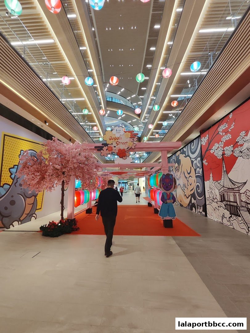 A person walks down a mall corridor decorated with Japanese-themed lanterns and artwork.