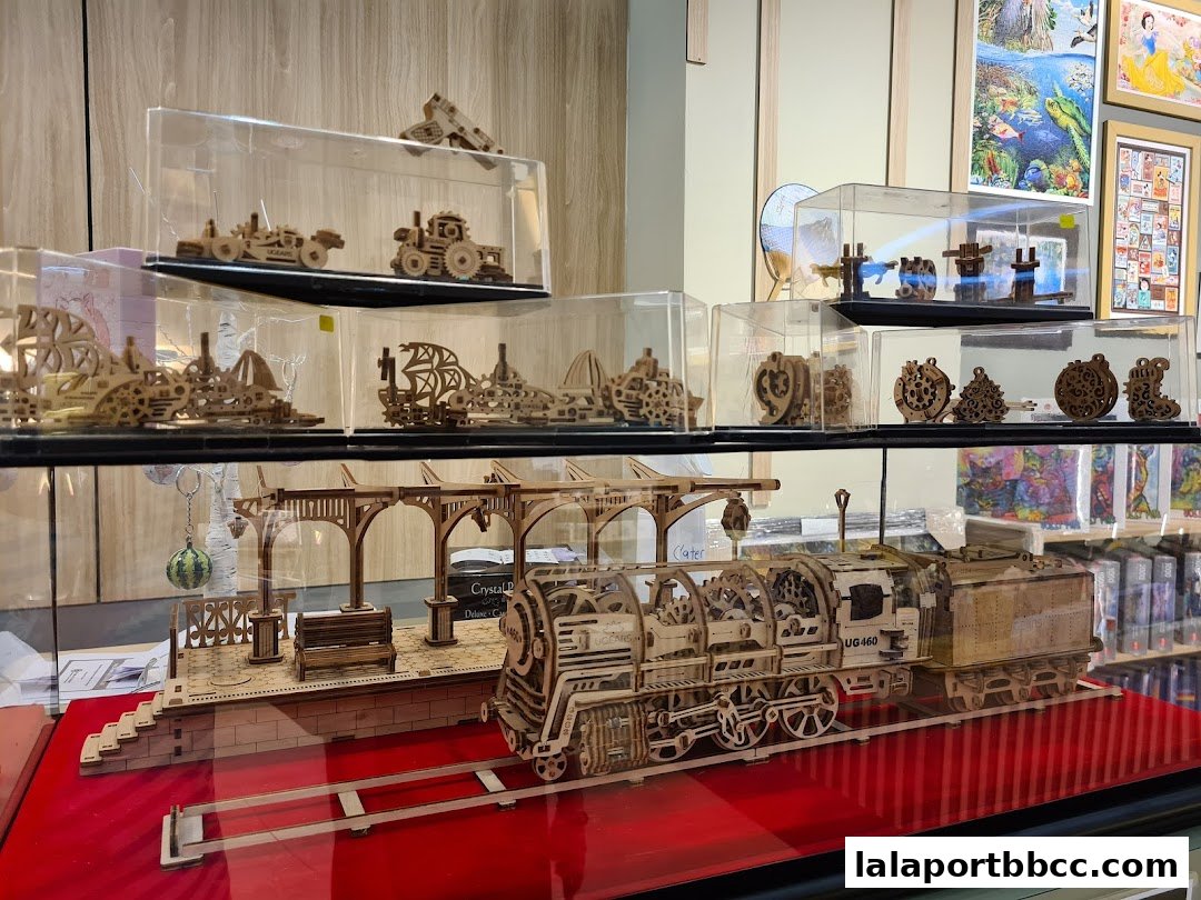 Display of intricate wooden mechanical models, including trains and vehicles, in a retail shop.