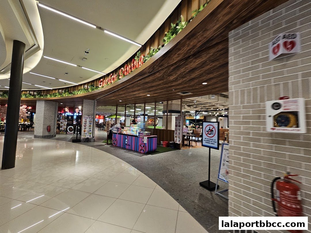A wide view of a modern food court with various dining options and seating areas.