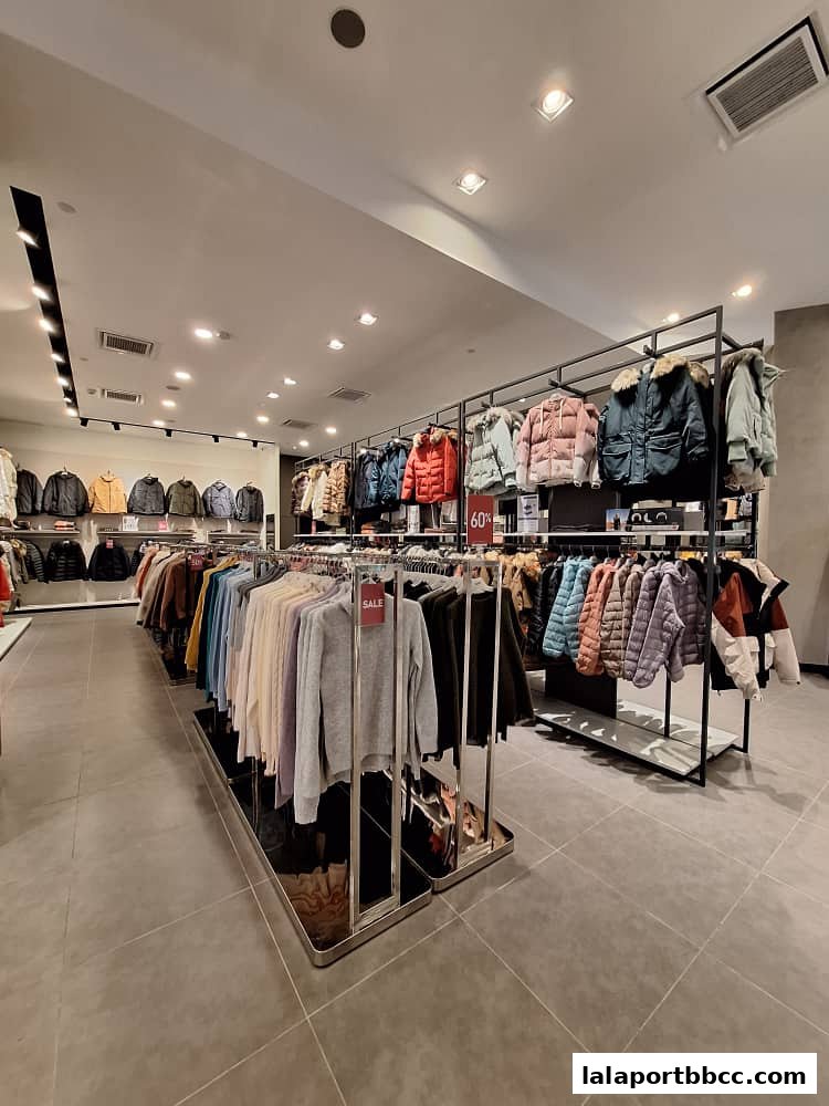 Interior view of a clothing store with racks of jackets and sweaters, some on sale.