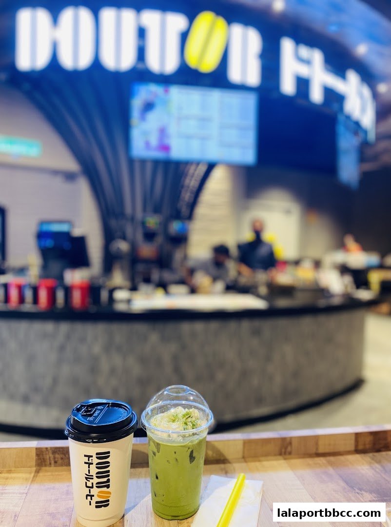 Two refreshing drinks, one hot coffee and one iced matcha, are displayed at a Doutor Coffee counter.