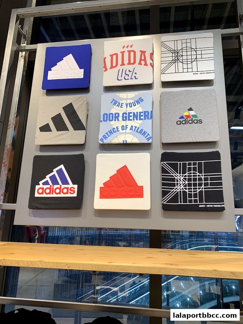 Display of various Adidas t-shirts with different logos and designs.