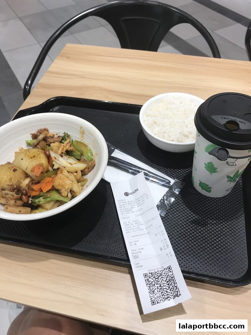 A tray with a bowl of fried rice, a bowl of white rice, a drink, and a receipt.