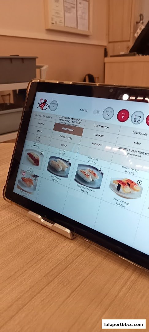 A tablet displaying a digital menu for Sushi King Lalaport BBCC with various sushi options.