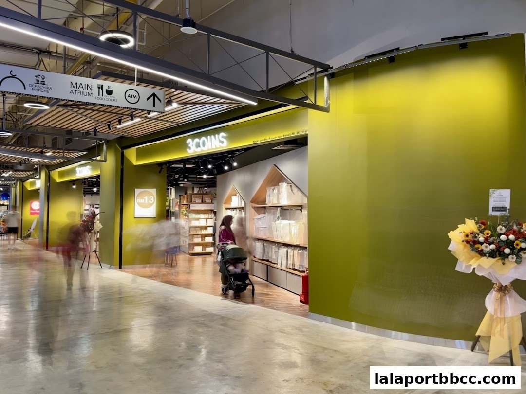 The entrance to 3COINS Lalaport BBCC, showcasing a bright yellow facade and interior displays.