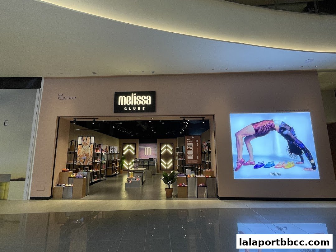 The entrance of a Clube Melissa shoe store, showcasing stylish footwear and a vibrant advertising display.
