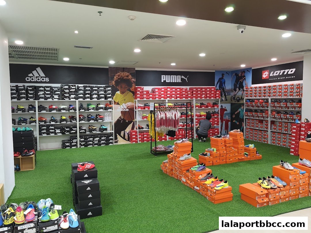 Interior of a sports shoe store with shelves stocked with shoes and branded displays.