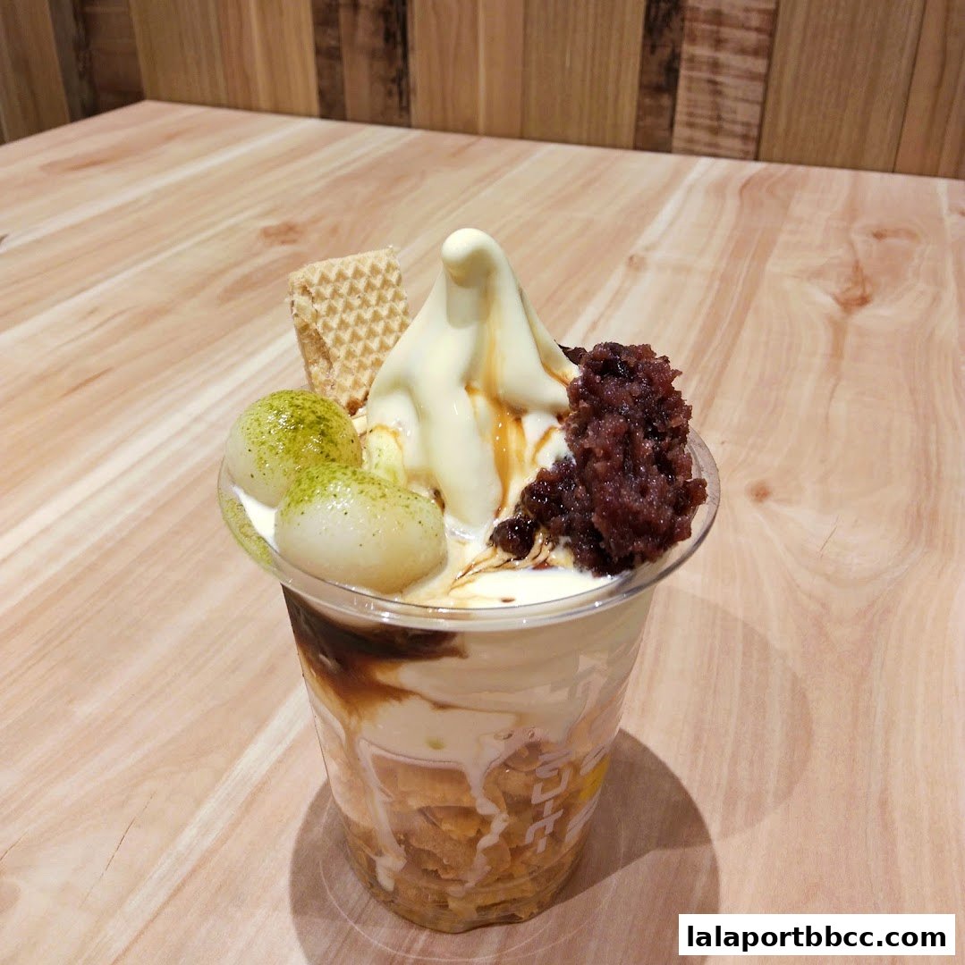 A delicious dessert parfait with soft serve ice cream, mochi, red bean paste, and a wafer.