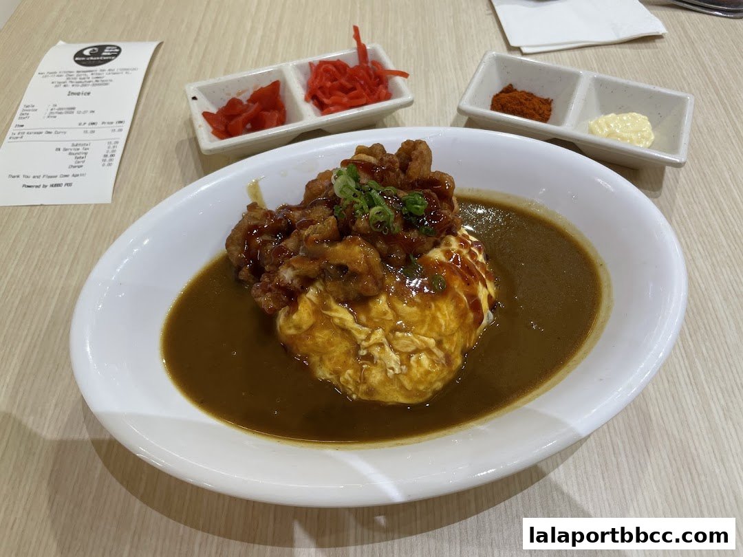 A delicious Japanese curry dish with fried chicken and omelet served with side condiments.