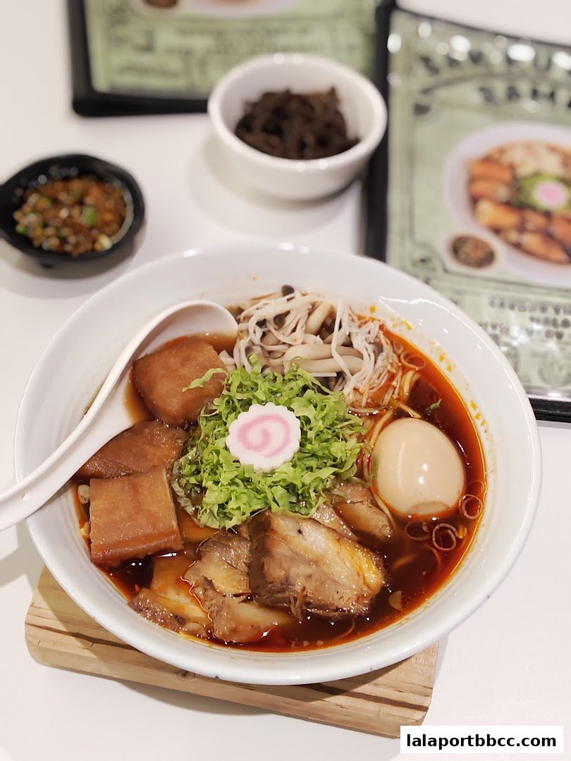 A delicious bowl of ramen with pork, egg, mushrooms, and green onions.