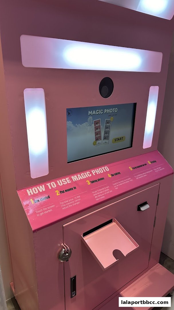 A pink Magic Photo booth with instructions on how to use it and a screen displaying photo options.